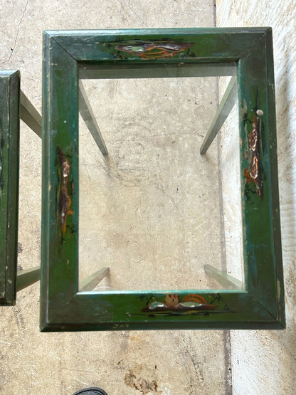 Top view of green lacquered nesting table frame, hand-painted scenes at corners, missing glass