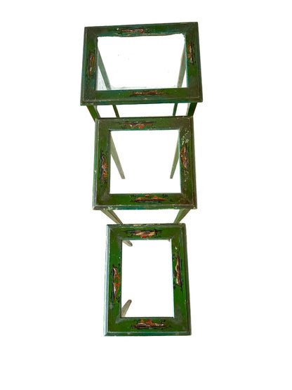 Vintage green lacquered nesting tables stacked vertically, showing graduated sizes and worn finish