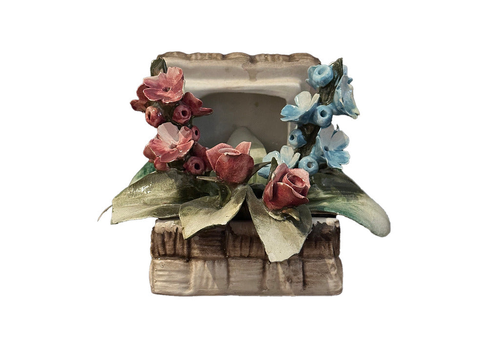 Capodimonte porcelain basket of flowers, front view, pink roses on the left and blue blossoms on the right