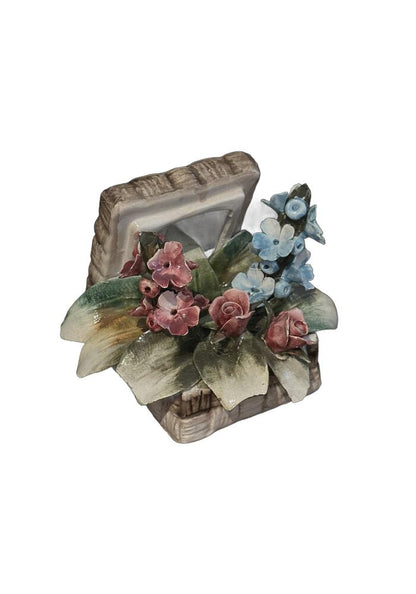 Capodimonte porcelain flower basket, high-angle view, pink roses and a spray of blue blossoms with green leaves