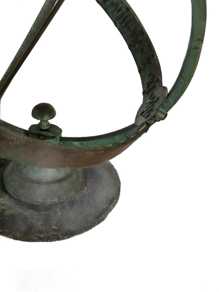 Detail of the sundial's engraved verdigris equatorial band and the knob mount on its stone base
