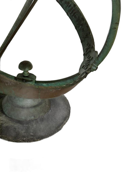Detail of the sundial's engraved verdigris equatorial band and the knob mount on its stone base