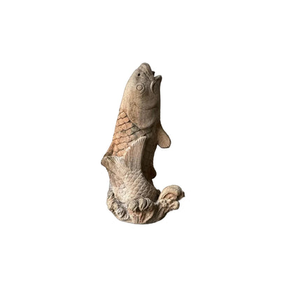 Vintage concrete koi fountainhead showing the upward-leaping carp and curling wave base