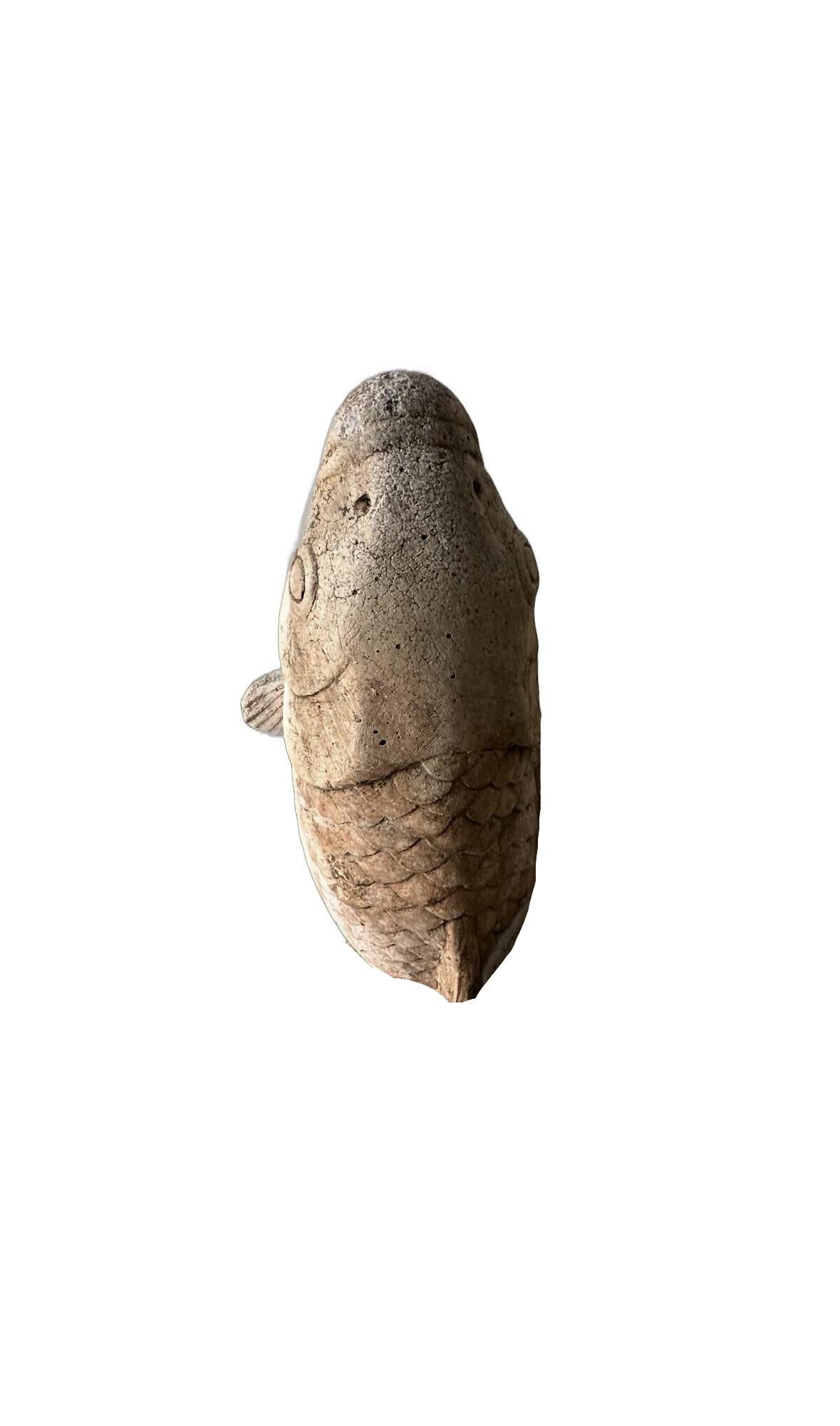 Overhead view of the vintage concrete koi fountainhead showing the carp's head and scales