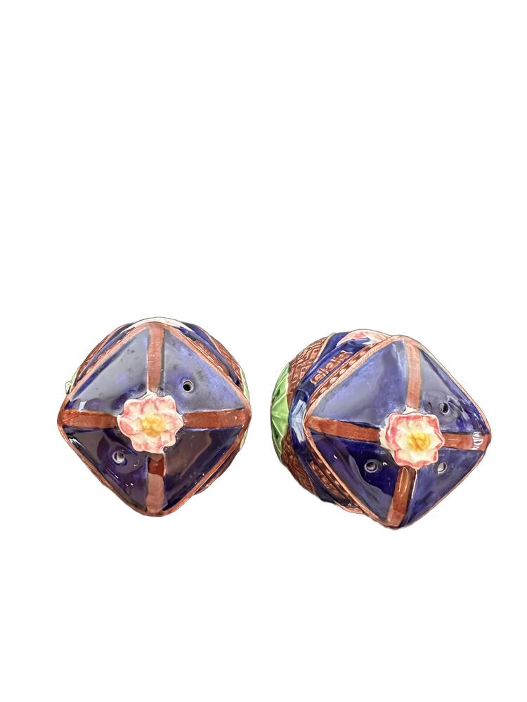Top view of ceramic salt and pepper shakers showing domed lids with floral finials