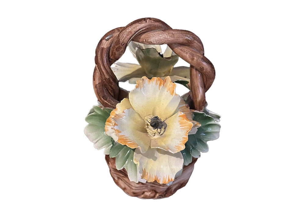 Capodimonte porcelain basket, top-down view of a yellow blossom framed by the braided handle.