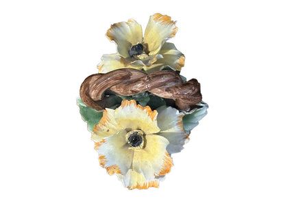 Capodimonte porcelain basket, overhead view of yellow ruffled blossoms around a braided handle.