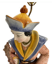 Close-up of male Capodimonte figure in blue and yellow hat with bowed head