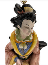 Close-up of female Capodimonte figure's painted face and black coiffed hair
