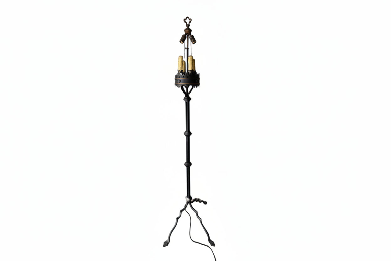 Wrought-iron floor lamp, fleur-de-lis finial over candle-style bulbs in a crown gallery, splayed tripod feet