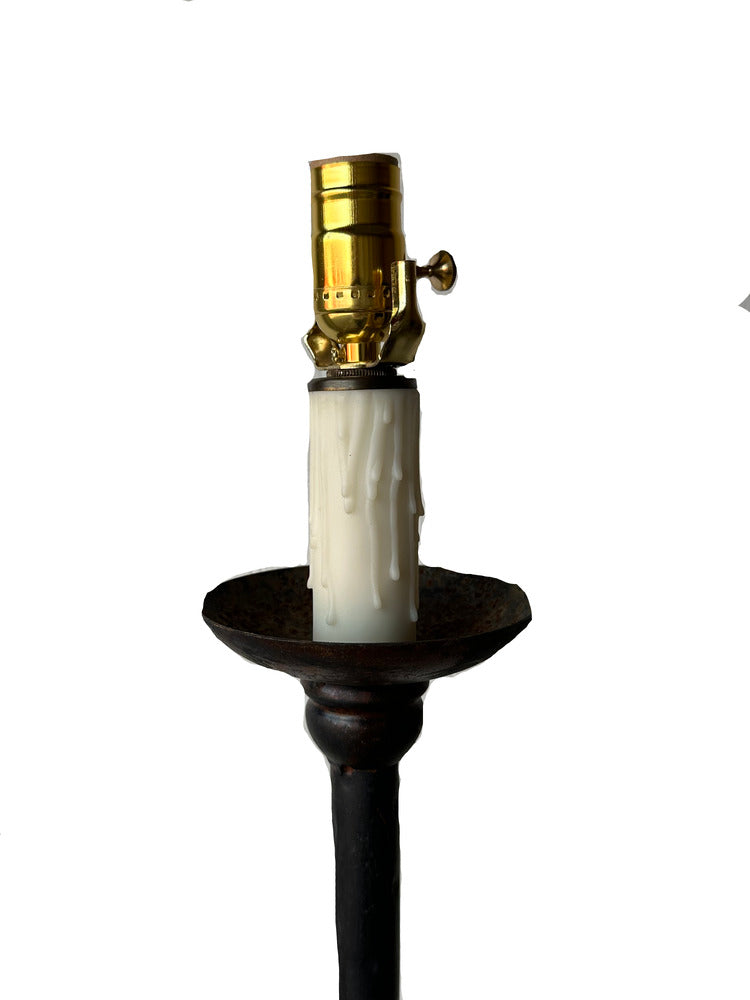 Close-up of floor lamp's brass socket and faux candle drip cover on iron bobeche