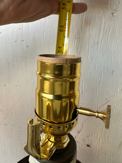 Detail of floor lamp's brass socket shown with a tape measure