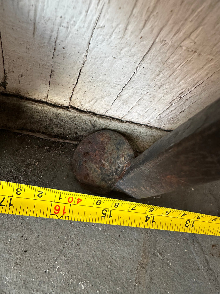 Close-up of iron floor lamp's forged ball joint and foot with tape measure