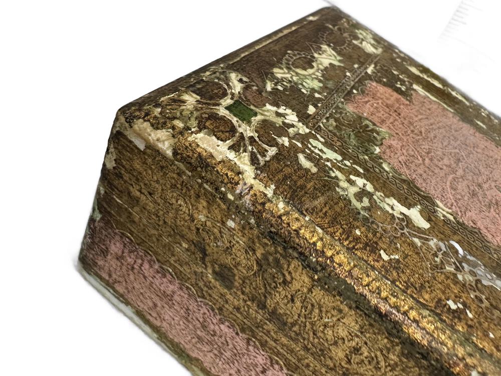 Close-up of Florentine box corner, heavily worn gold-leaf finish with traces of pink and green patina