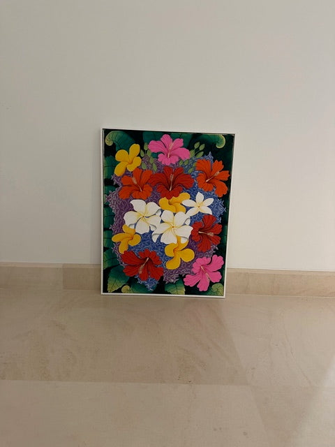 Vintage tropical Balinese painting, framed floral artwork leaning against a wall on a tiled floor