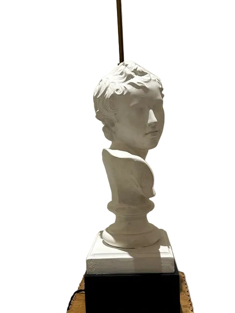 Three-quarter view of the white plaster youth bust on a socle base with brass lamp rod