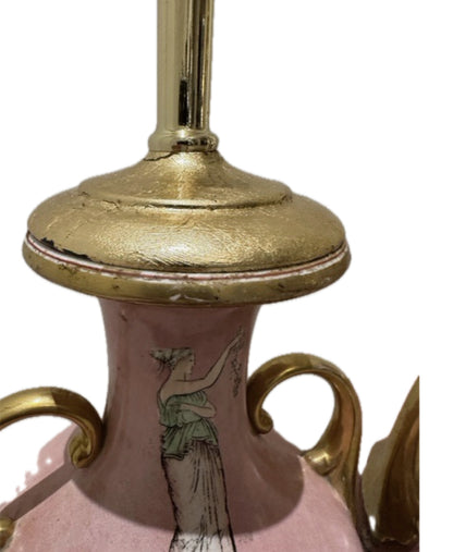Detail of a pink lamp's gilt neck cap with visible wear above a painted classical figure