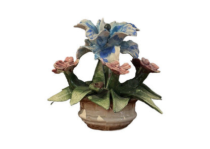Front view of Capodimonte porcelain flower basket with blue bloom, pink roses and green leaves