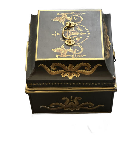 Vintage tole hinged box, angled top view with raised brass swing handle and gilt bird-and-urn lid motif