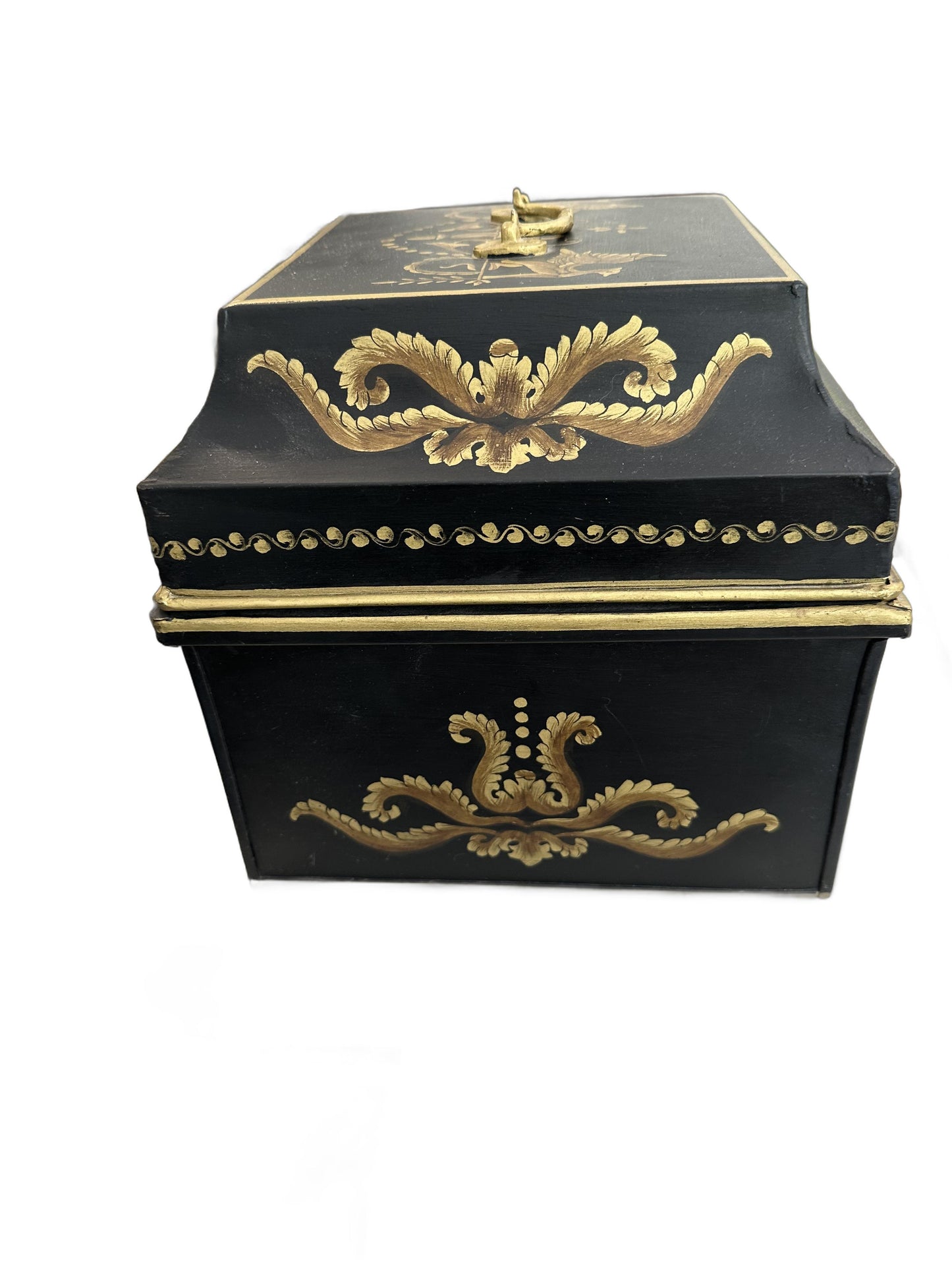 Vintage tole hinged box, three-quarter view of the black body with gilt foliate swag motifs