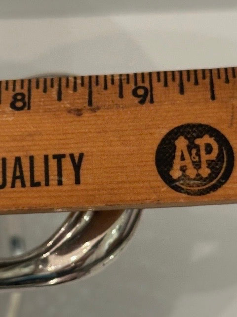 Silver-plate ice tongs measured against a wooden ruler near the eight-inch mark
