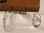 Silver-plate ice tongs laid against a wooden ruler to show overall length
