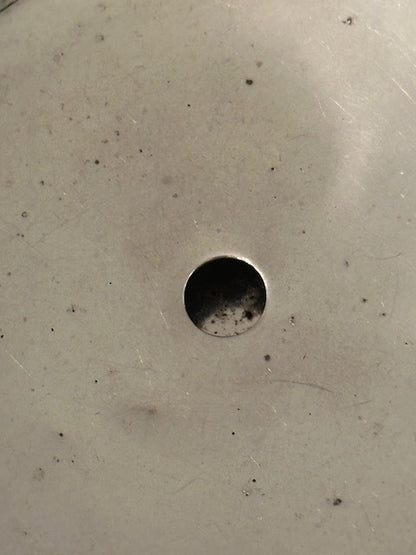 Hammered silver-plate ice bucket; close-up of the worn interior base and drain hole
