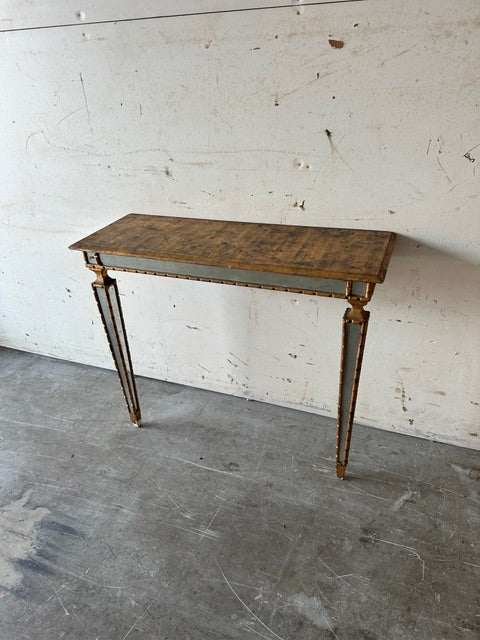 Italian pier table, three-quarter view against a wall showing tapering mirrored legs