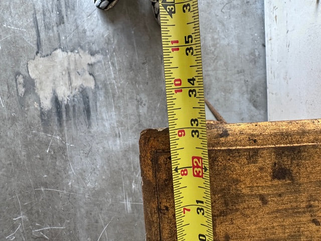 Close-up of the pier table's leg base with a tape measure showing height near 32 inches
