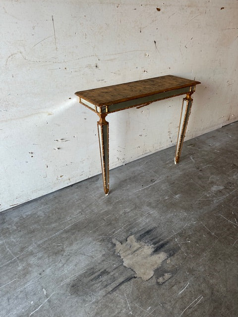 Italian pier table at an angle against a wall, gilt-trimmed apron and mirrored legs