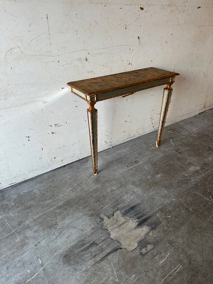 Italian pier table at an angle against a wall, gilt-trimmed apron and mirrored legs