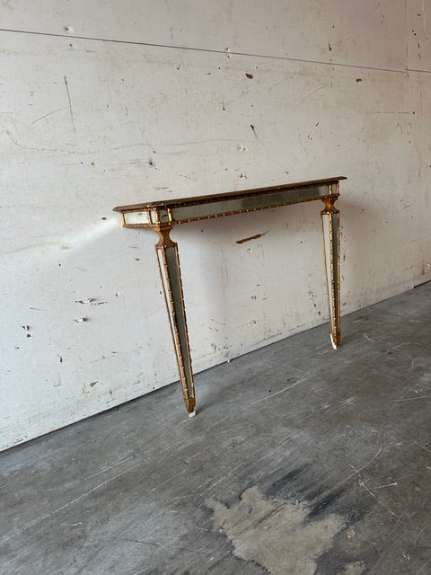 Italian pier table, angled view highlighting mirror-paneled tapering legs and apron