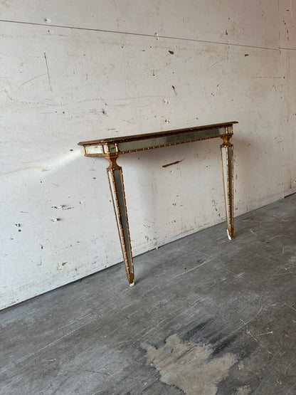 Italian pier table, angled view highlighting mirror-paneled tapering legs and apron