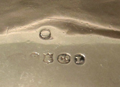 Close-up of the maker's hallmark stamps on the underside of the silver pitcher
