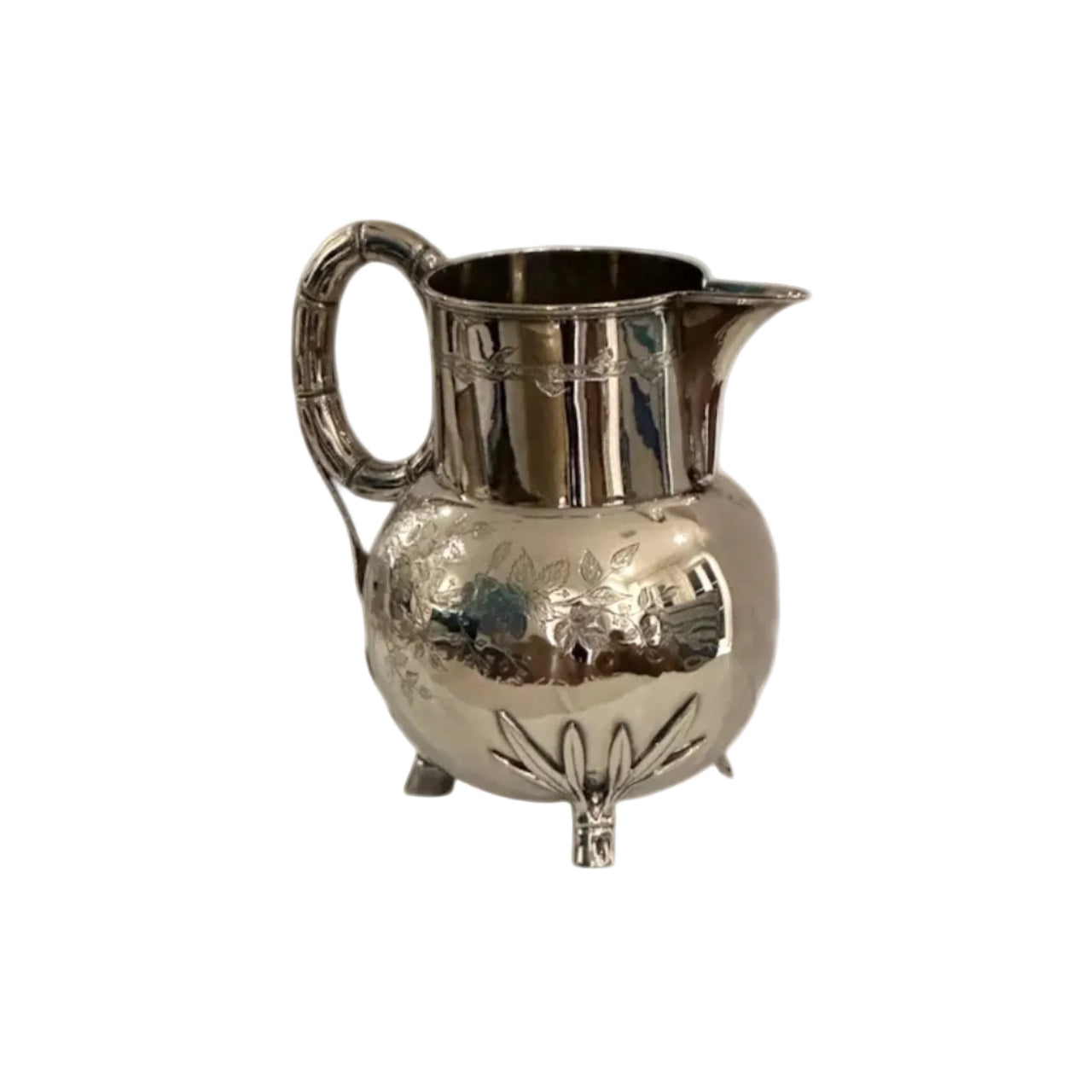 Art Nouveau silver plate pitcher, three-quarter view, bulbous footed body with bamboo loop handle and floral repoussé