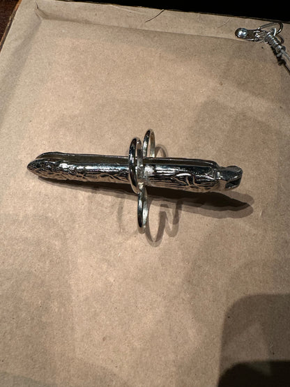 Side view of a hinged silver plate asparagus utensil with finger loops