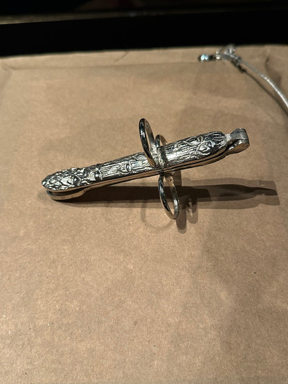 Silver plate asparagus utensil, angled view of foliate handle and three finger loops