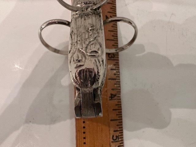Close-up of the asparagus utensil's foliate-embossed handle and hinged grip