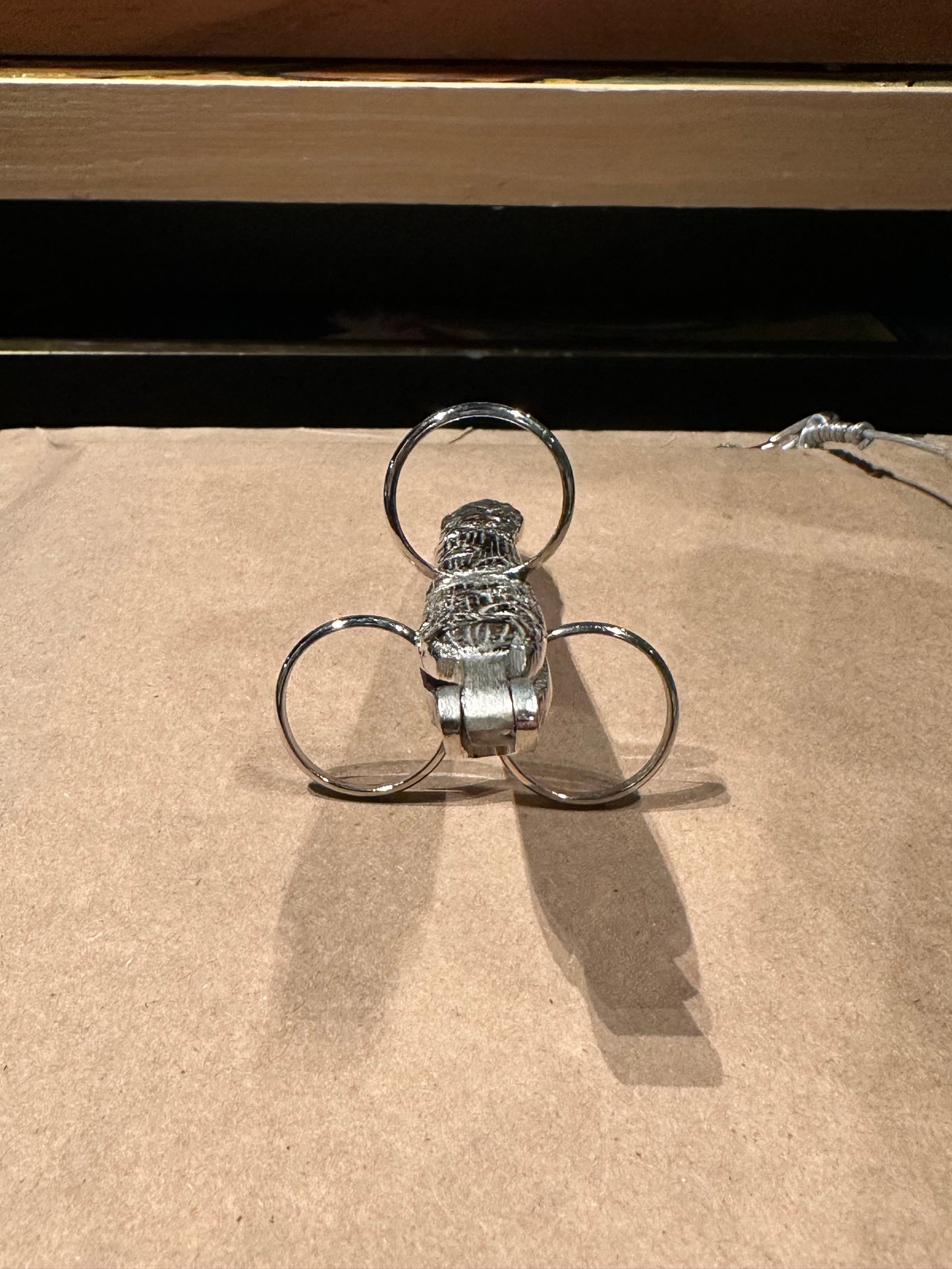 End-on view of an asparagus utensil with three finger loops arranged like a clover