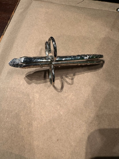 Hinged asparagus utensil laid flat showing full length, foliate handle and finger loops