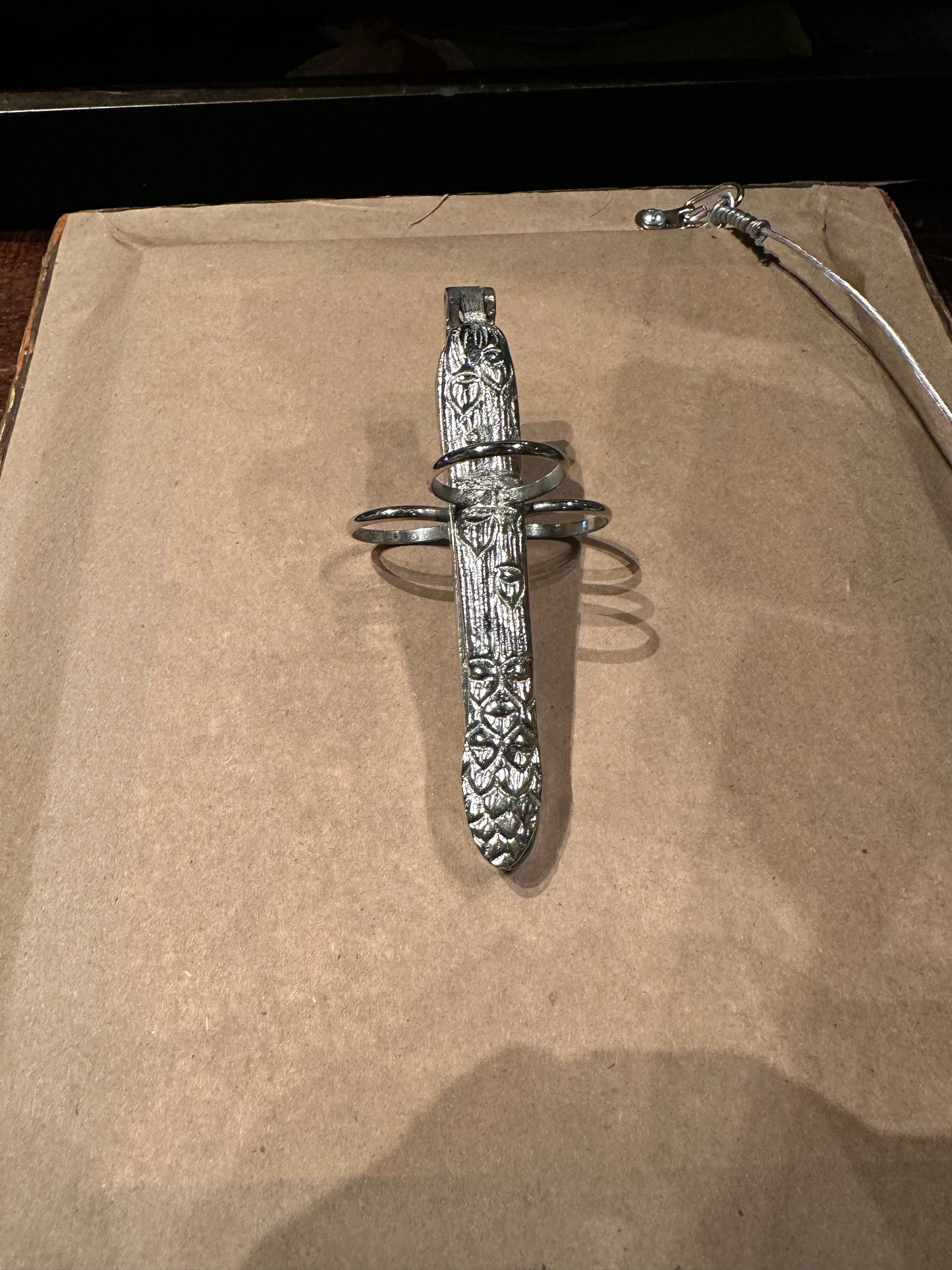 Silver plate asparagus utensil with foliate-embossed handle and three finger loops