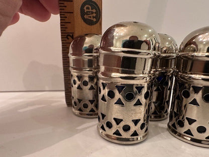 Pierced EPNS shakers beside a wooden ruler showing about two inches tall
