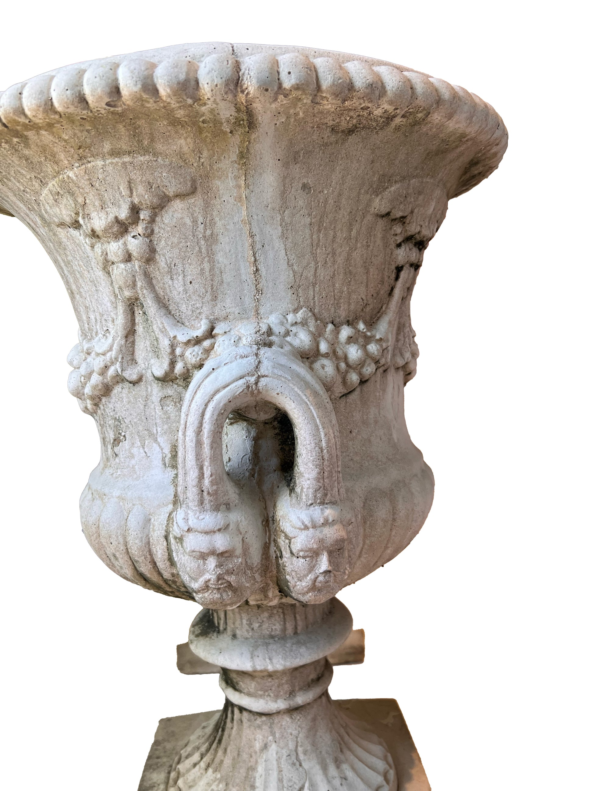 Close-up of a concrete urn bowl showing a figural mask handle and carved fruit swags