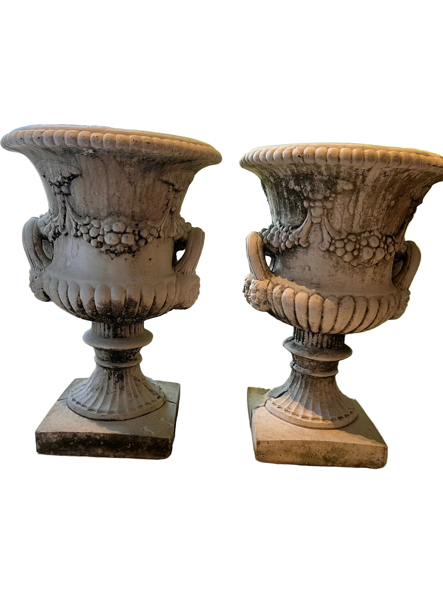 Pair of concrete Regency urns, three-quarter view, fluted pedestals and weathered surface