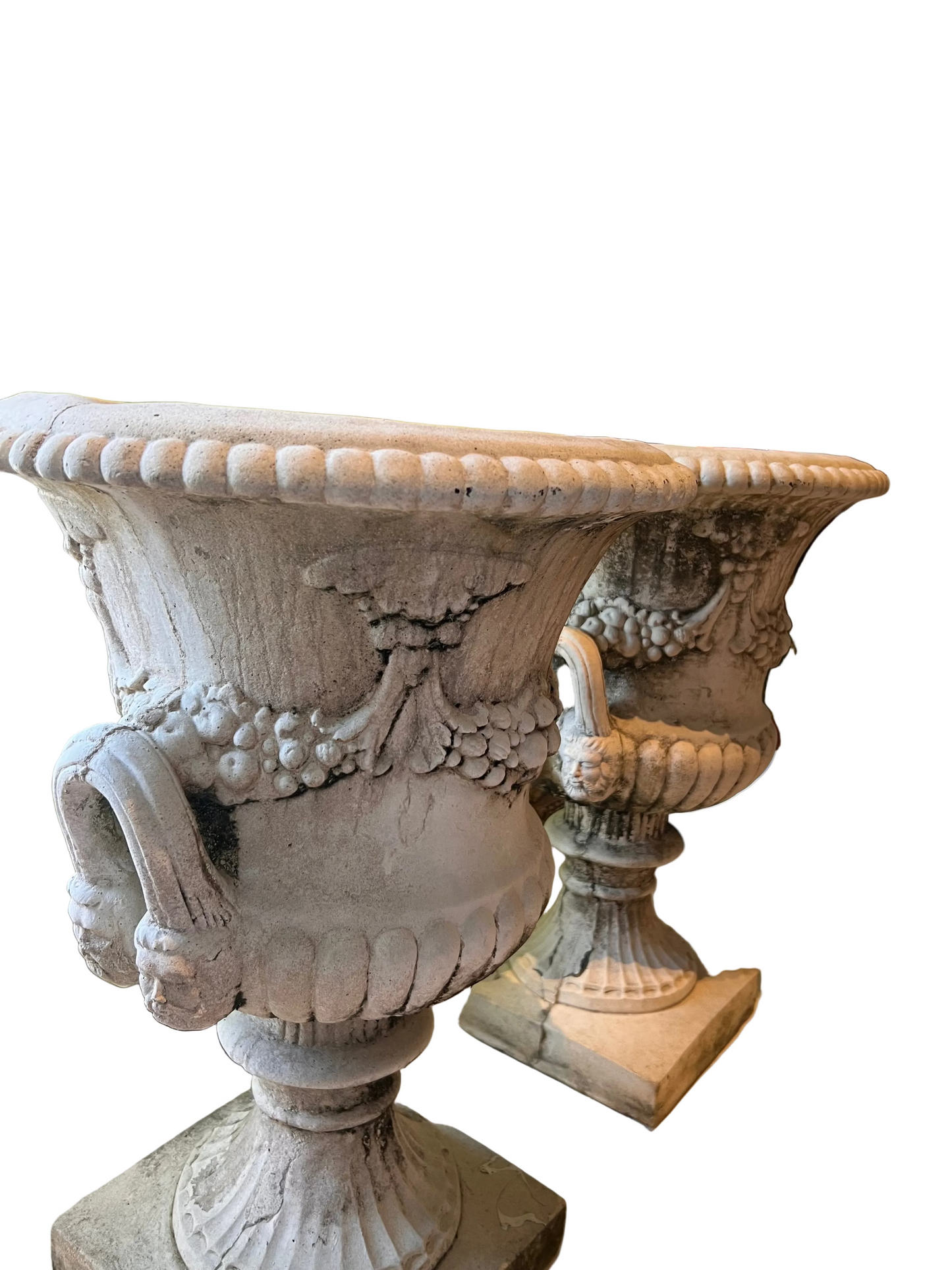 Angled top view of both concrete urns showing their rims, handles and fluted feet