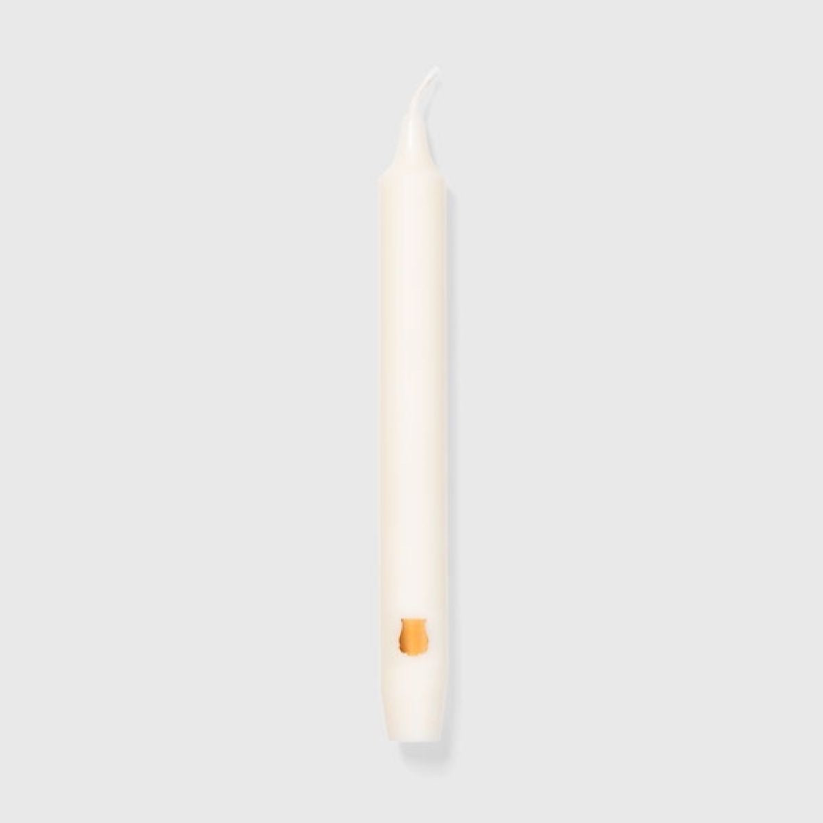 Single Trudon Madeleine ivory-white taper candle with small gold Trudon emblem near the base