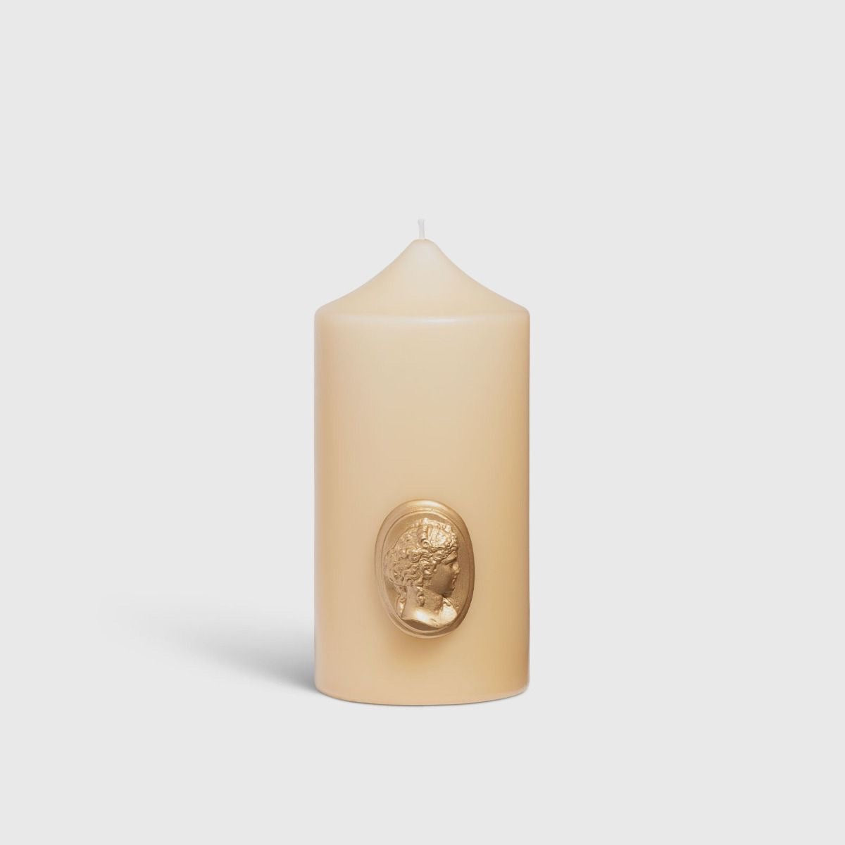 Green Trudon candle on a black-and-gilt pedestal beneath a dark bronze classical figure