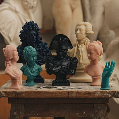 Trudon bust candles grouped on a wooden table, rose Marie-Antoinette among other busts