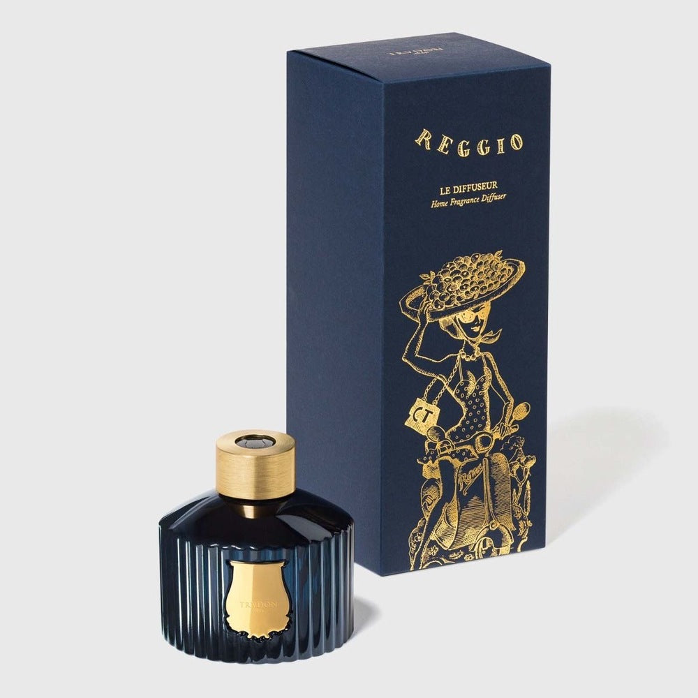 Trudon Reggio diffuser bottle beside navy gift box with gold scooter illustration, citrus scent