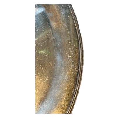 Close-up of the oval tray's well showing fine surface scratches and wear.